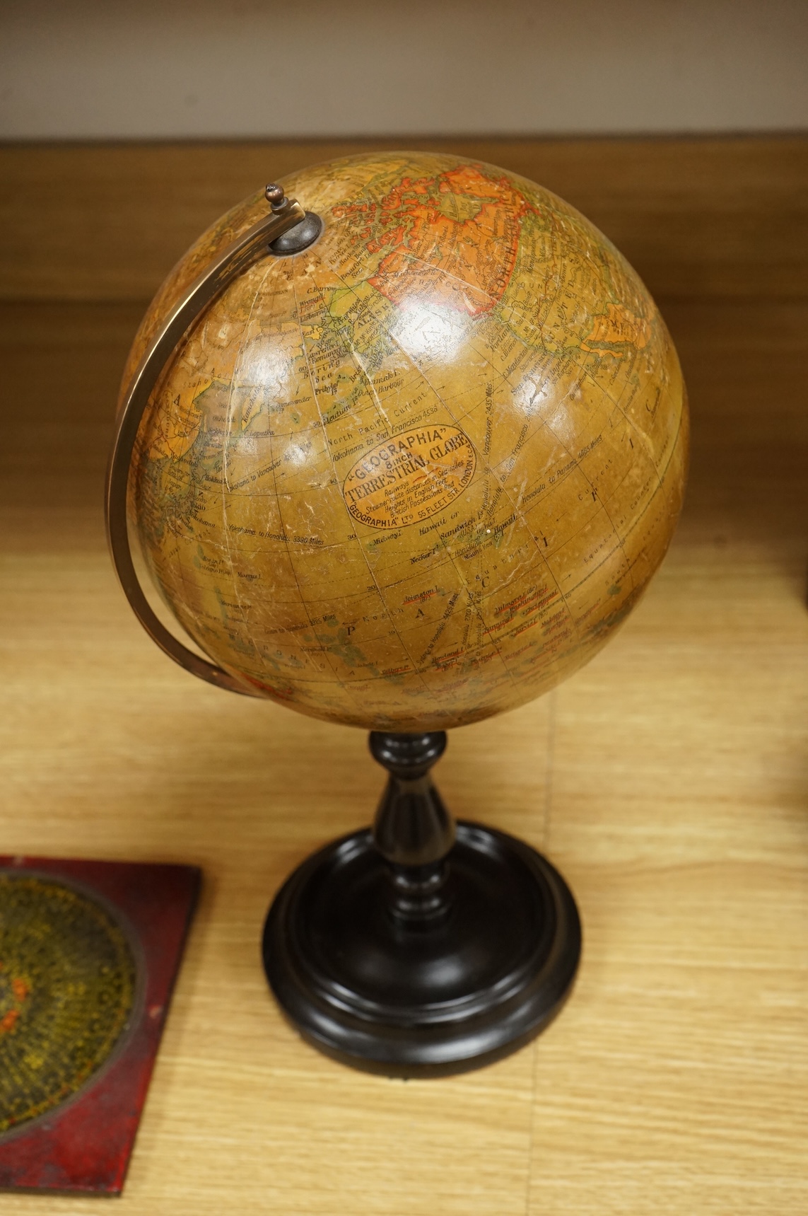 A Geographica 8 inch globe on a turned ebonised wood stand, 39cm high, together with a Chinese ‘Luopan’ compass, for use in feng shui practice.